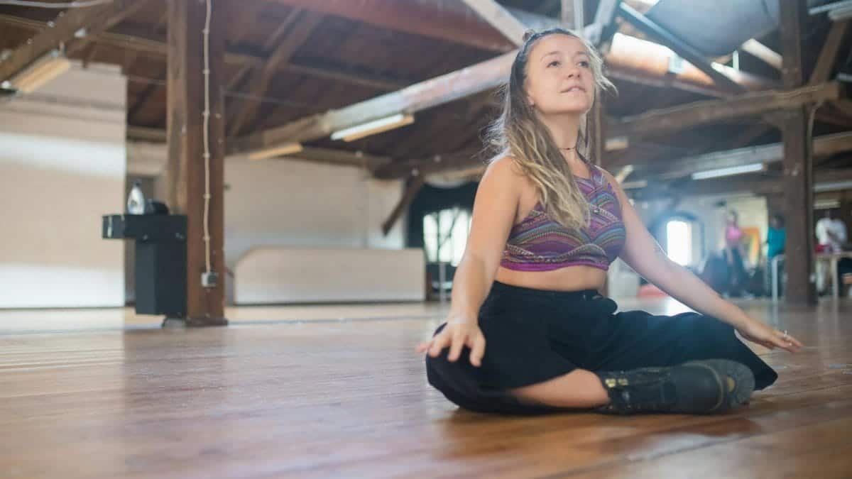 Caucasian woman meditating on a wooden floor in a rustic studio. Calm and peaceful environment.