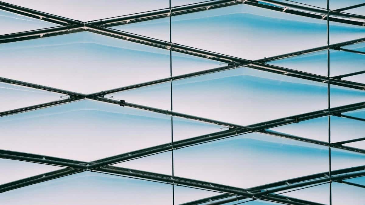 Low angle view of a modern geometric metal structure with a blue sky background.