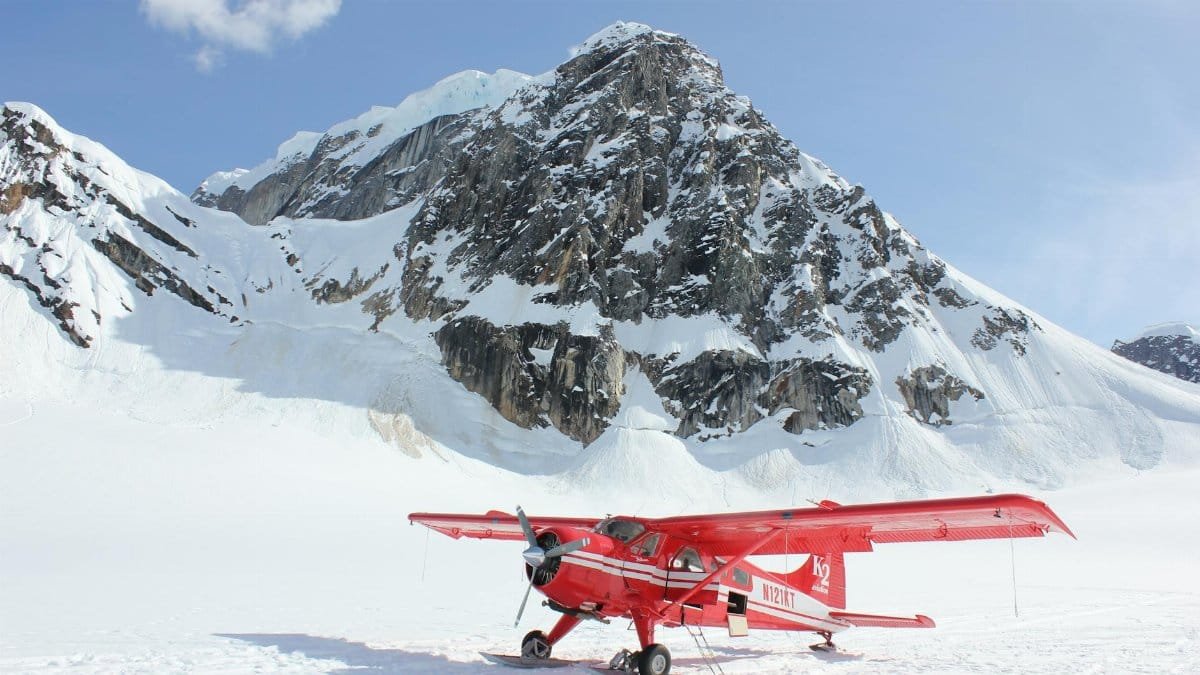 Vibrant red plane on the snowy terrain of Denali National Park, Alaska.