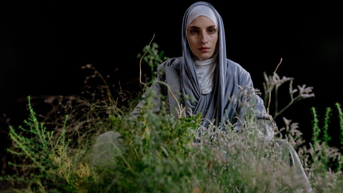 Studio portrait of a woman in hijab with a natural setting background.