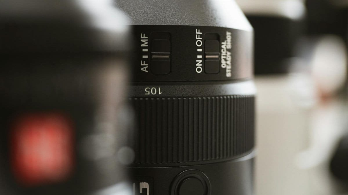 Detailed close-up image of a professional camera lens showing controls and dials for settings.