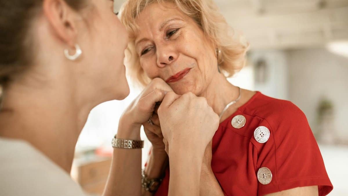 A touching scene showing affectionate connection between two women indoors.