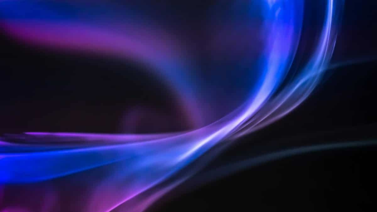 Vibrant abstract swirls of blue and purple light creating a dynamic visual effect.