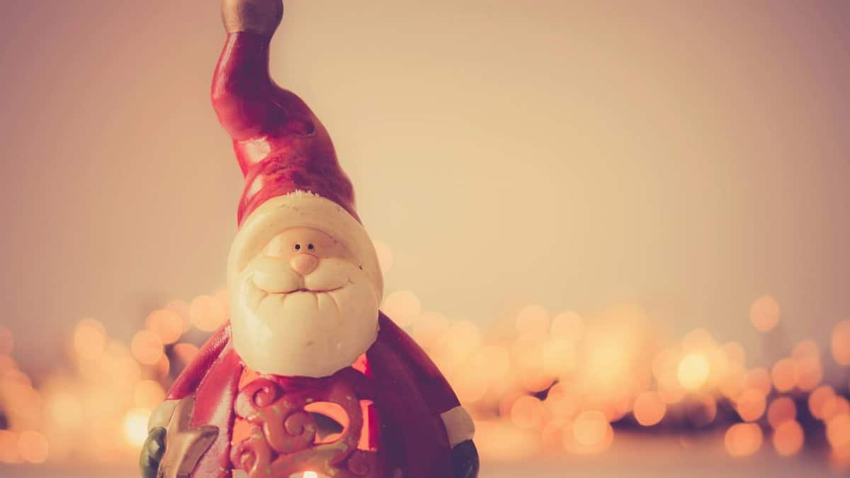 Charming Santa Claus figurine with festive bokeh lights creating a warm Christmas atmosphere.