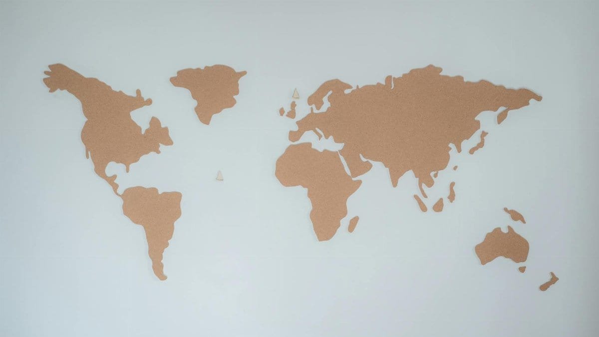 A minimalist cork board world map displayed on a white wall provides modern decor inspiration.