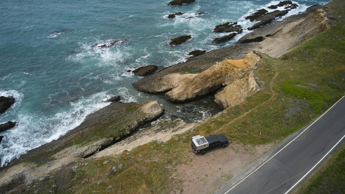 Aerial view of a coastal road and rocks by the ocean in Point Arena, California.