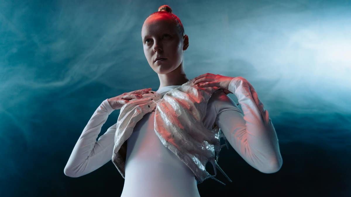 A model in an avant-garde outfit with ethereal lighting and smoke effect, showcasing futuristic fashion.