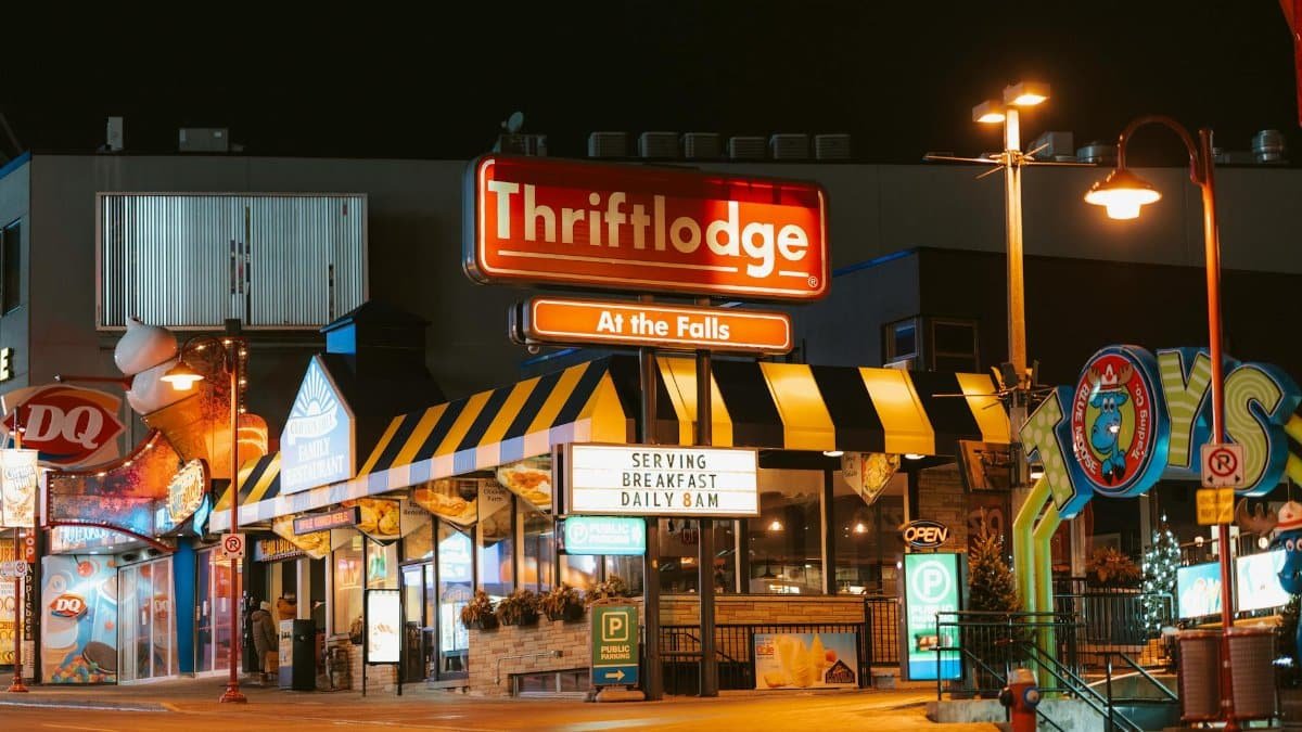 Colorful night view of Niagara Falls street with shops and eateries.