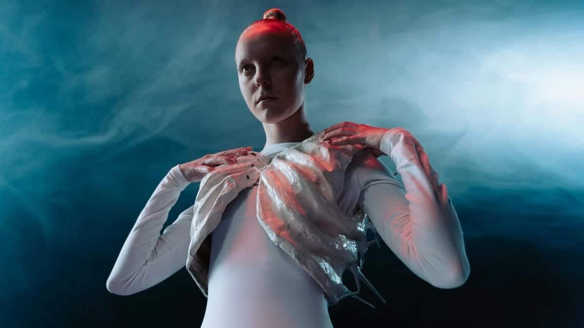 A model in an avant-garde outfit with ethereal lighting and smoke effect, showcasing futuristic fashion.