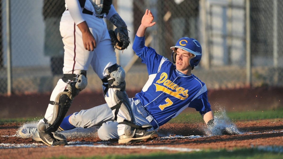 A thrilling moment of a baseball player sliding into home base during a competitive game.