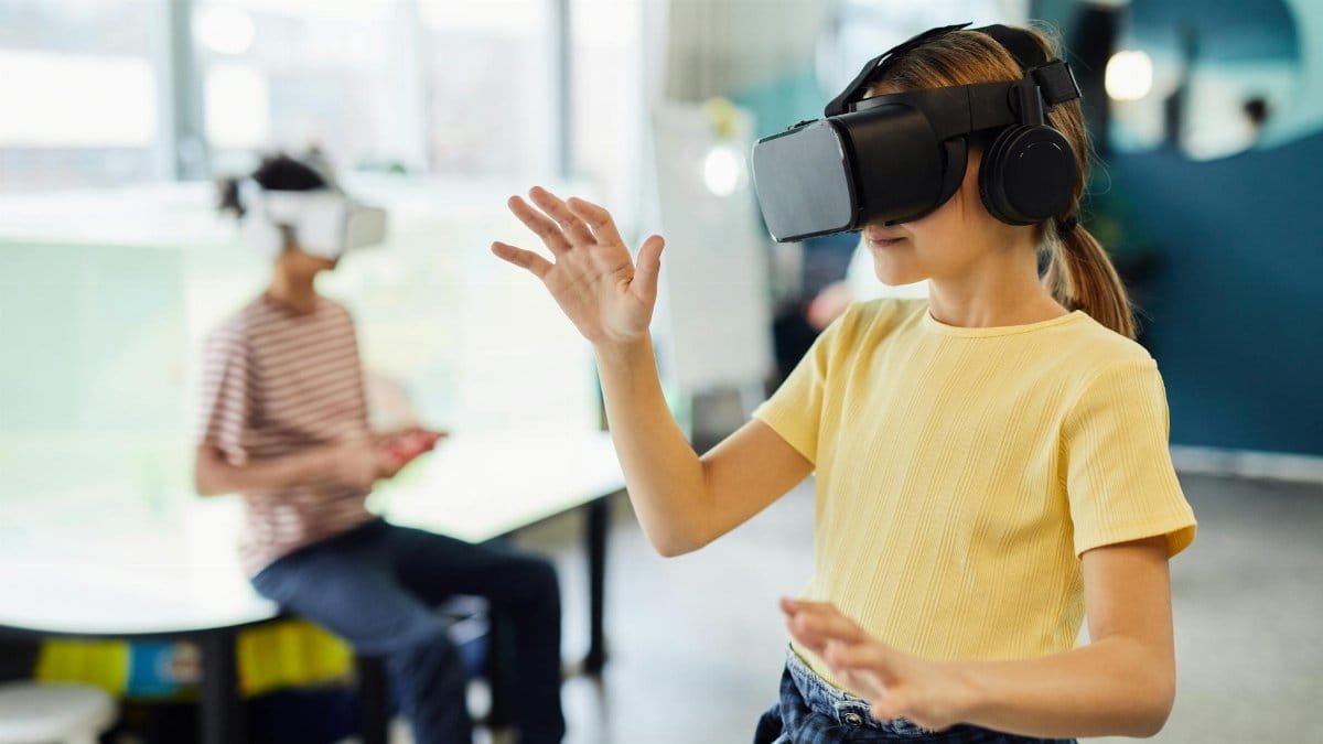 Young female in VR glasses standing in light room and testing new device