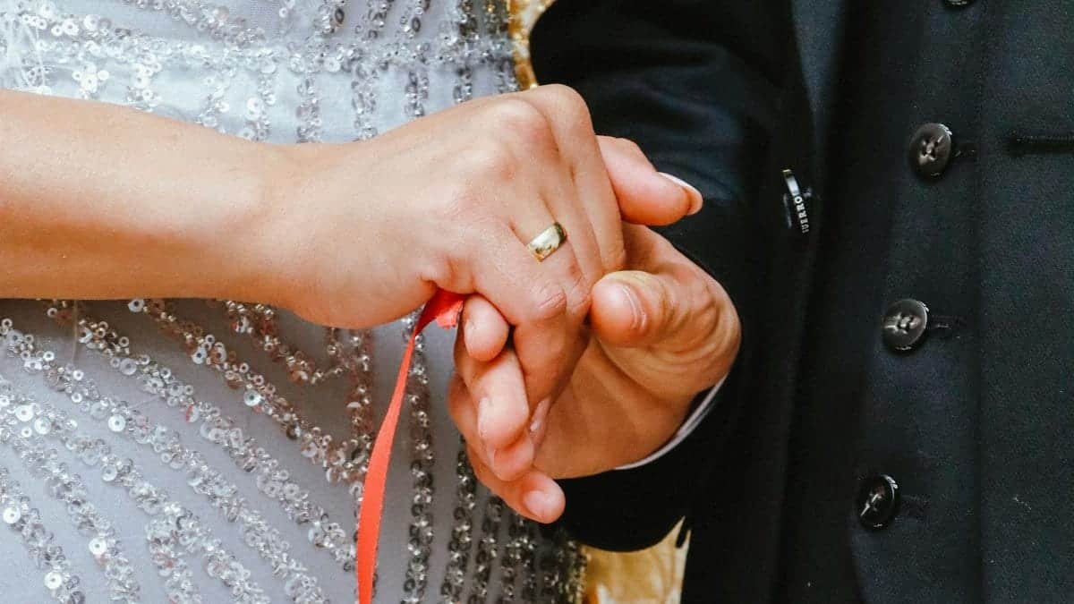 Close-up of a couple's handbinding ritual, symbolizing unity in marriage.