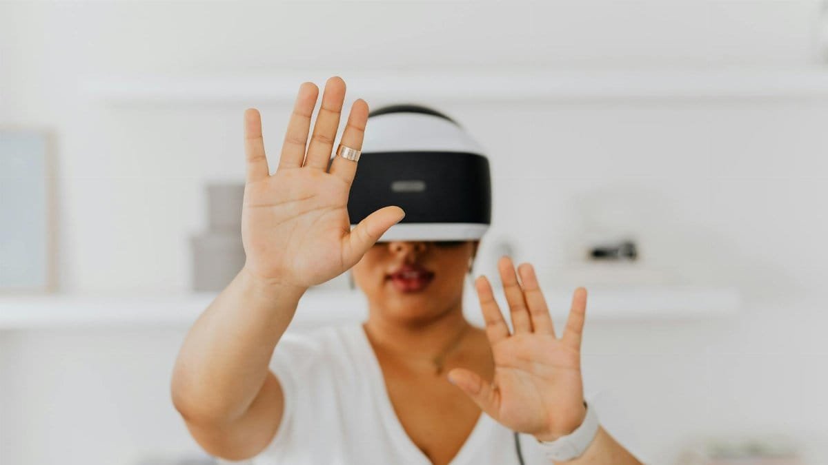 A woman interacts with virtual reality technology using a VR headset indoors.