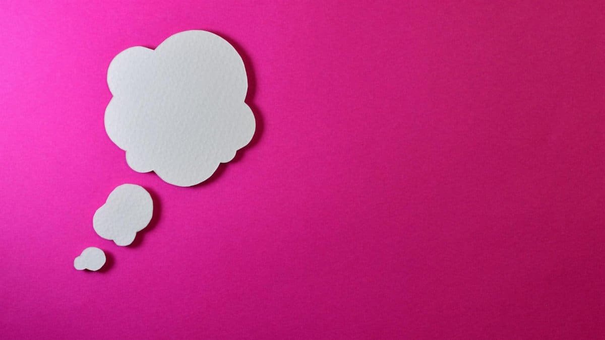 Paper thought bubble over bright pink background, ideal for creative concepts.