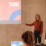 Young woman presenting on digital evolution concepts like AI and big data in a seminar.