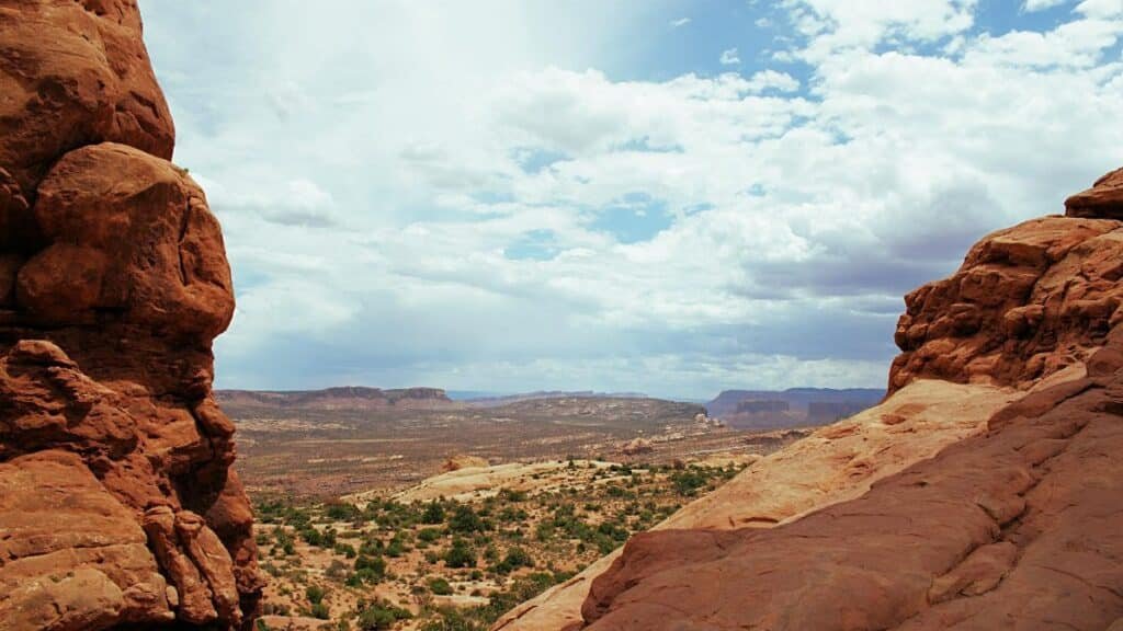 A stunning view of red rock formations and vast desert under a wide sky in Utah.