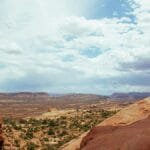 A stunning view of red rock formations and vast desert under a wide sky in Utah.