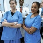 A diverse team of doctors and nurses smiling confidently in a hospital setting.