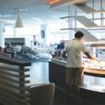 Stylish airport lounge with buffet and seating, featuring sleek interior design and contemporary furniture.