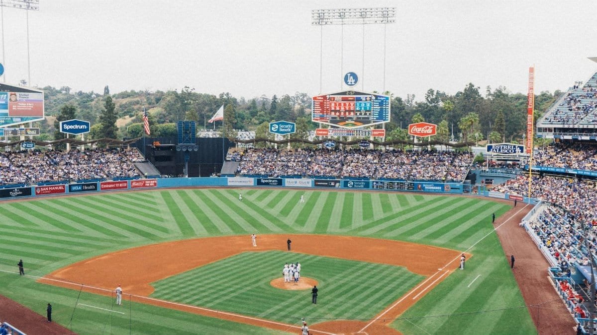 Vibrant baseball game at Dodger Stadium with packed stands and players on the field.