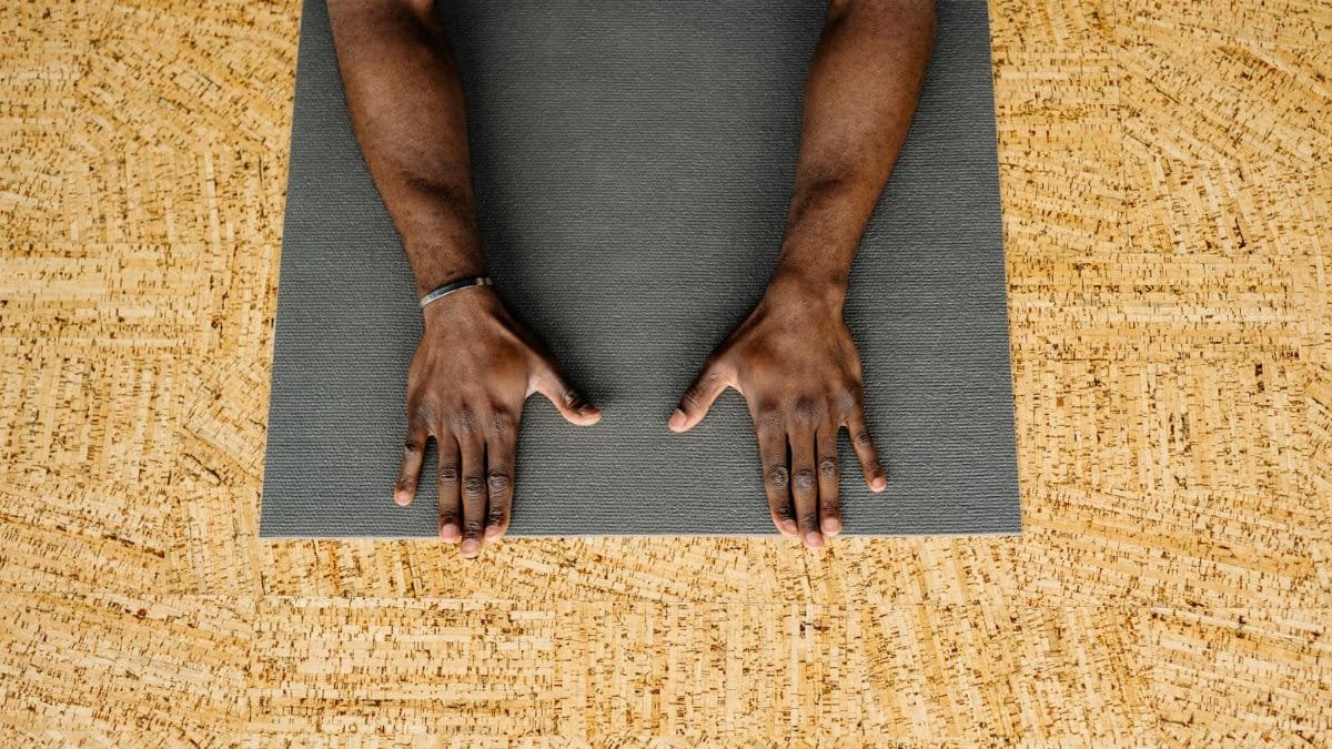 A man in a yoga pose on a mat within an indoor studio, focusing on relaxation.
