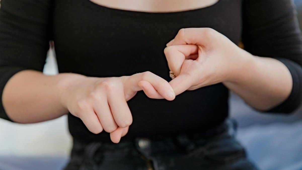 A woman gesturing in sign language, emphasizing non-verbal communication.