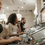 Stylish women engage in casino gaming at slot machines, showcasing elegance and excitement.