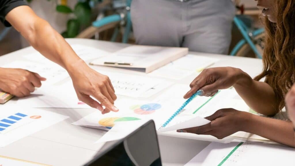 A diverse team collaborating on business strategies with charts and documents in an office setting.
