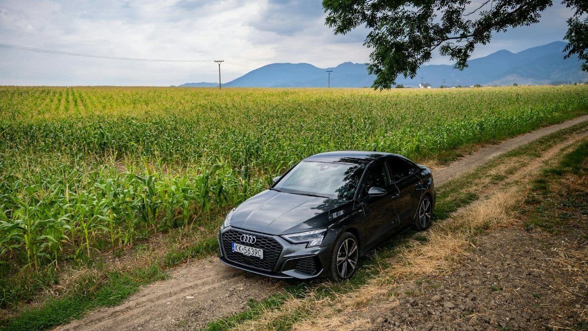 Audi sedan driving on a rural dirt path beside cornfields in Martin, Slovakia.