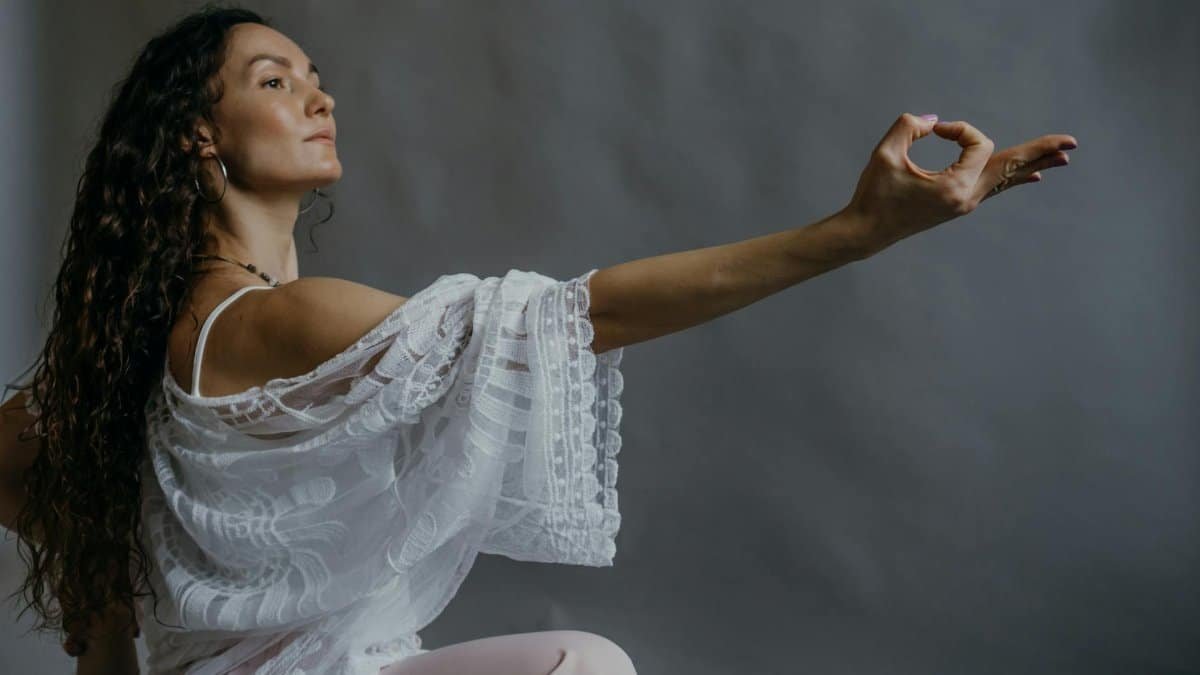Woman practicing yoga pose with graceful expression indoors.