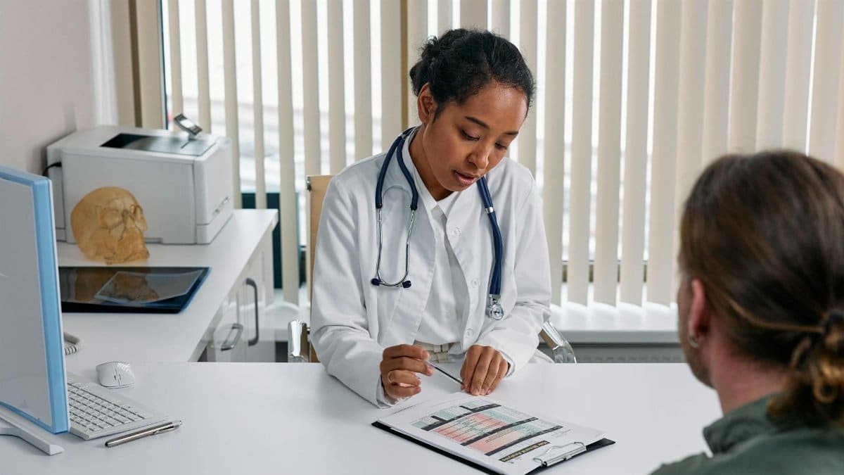 A doctor consulting with a patient in an office, discussing a medical chart.