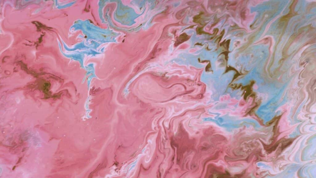 Colorful marbled texture with swirling pink, blue, and beige patterns creating a vibrant abstract artwork.