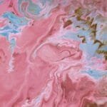 Colorful marbled texture with swirling pink, blue, and beige patterns creating a vibrant abstract artwork.