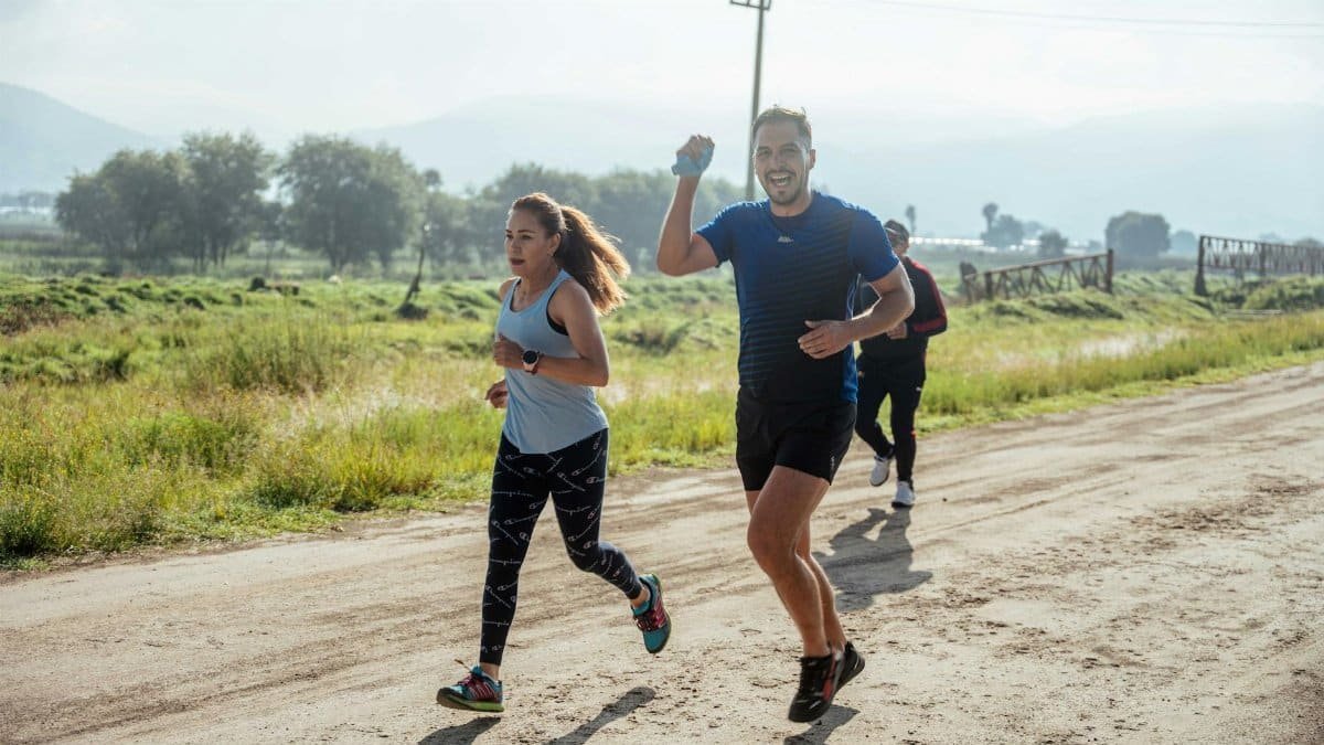 A group of runners enjoys a vibrant morning jog on a rural dirt road.