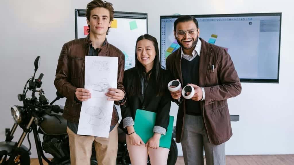 Diverse young entrepreneurs showcasing a new product prototype in a modern office.