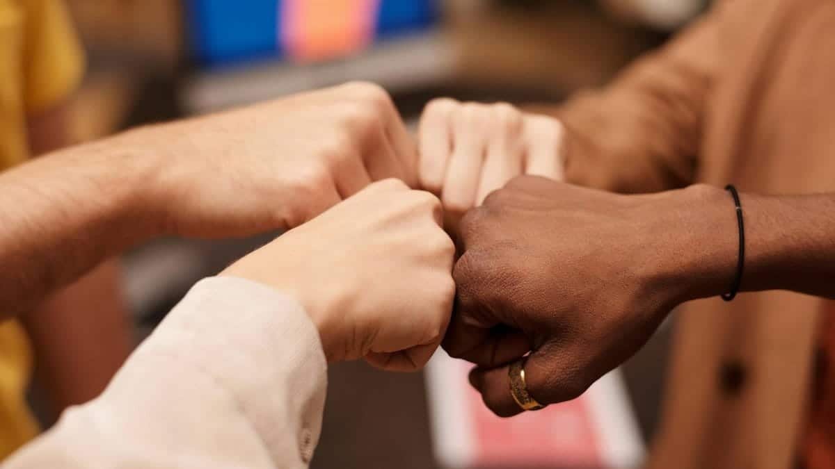 Close-up of a diverse group doing a fist bump, symbolizing teamwork and unity.