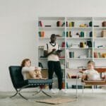 Psychologist conducts a therapy session with children in a modern library setting.