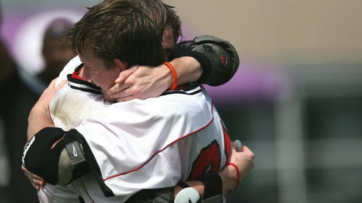 Athletes celebrating a victory with an emotional embrace on the field.