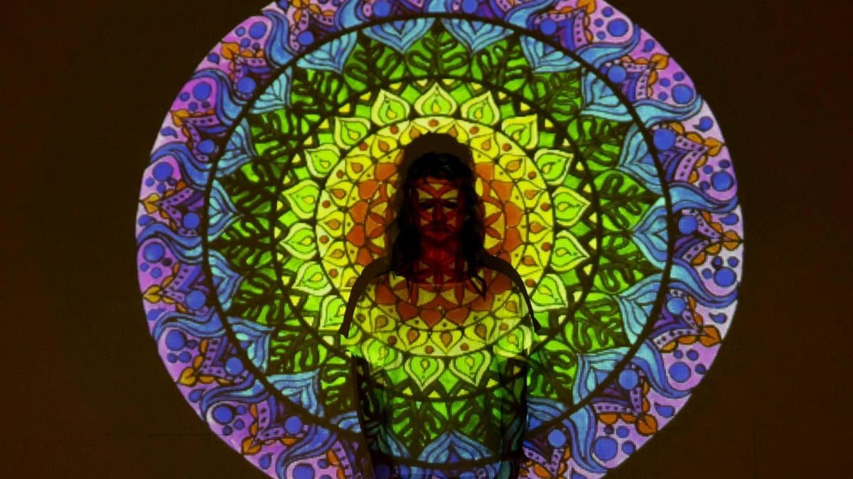 Vibrant mandala projected onto person, creating a fusion of colors and shapes.