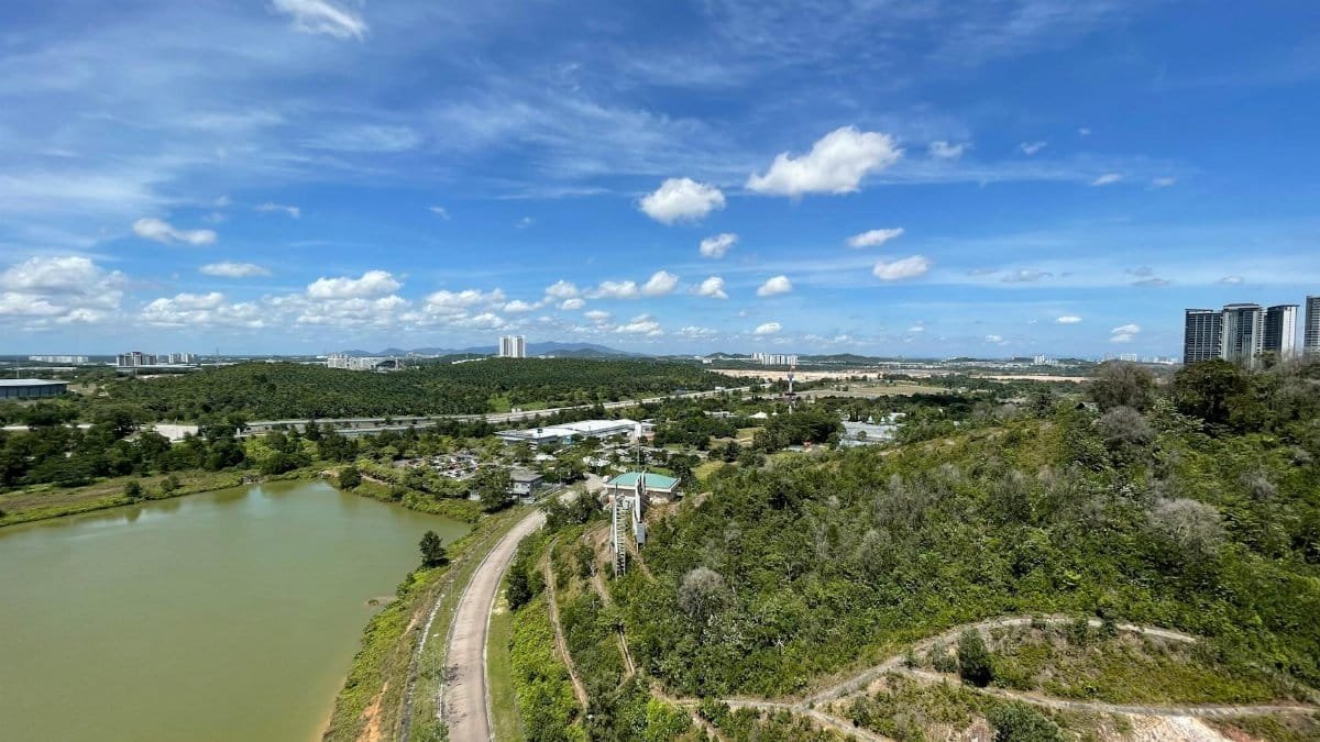 Stunning aerial photograph of Nusajaya, Johor with lush greenery and a vibrant skyline under a blue sky.