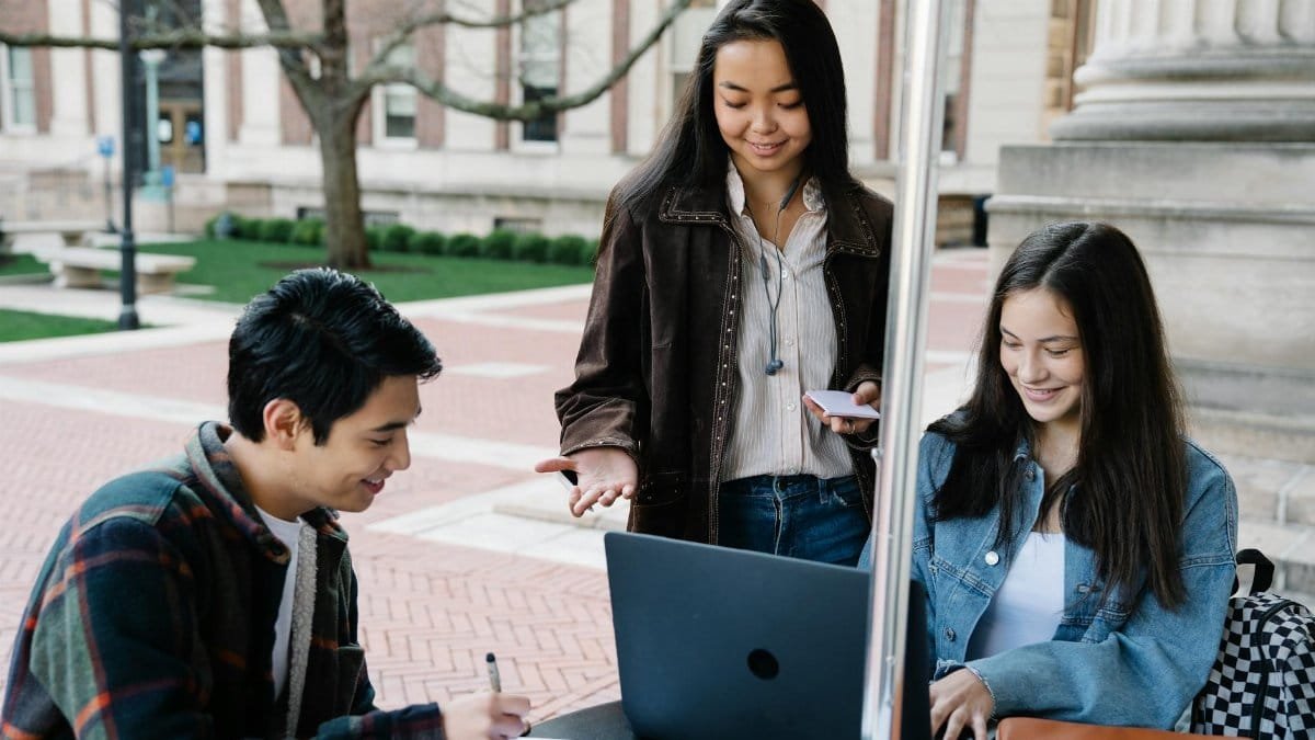 Group of university students collaborating and studying together in an outdoor setting.