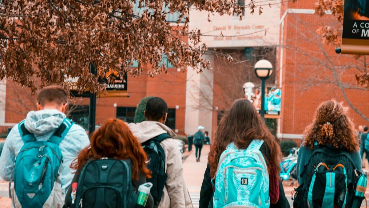 A group of college students with backpacks walking together outdoors on campus.
