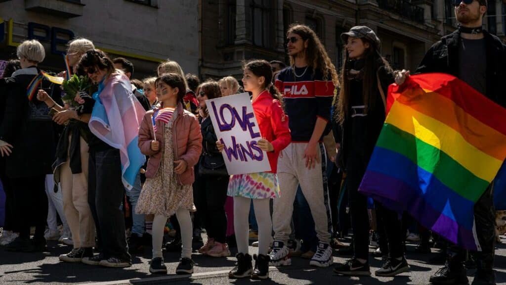 Celebrate diversity with a vibrant Pride parade featuring a Love Wins sign and rainbow flag in Riga, Latvia.