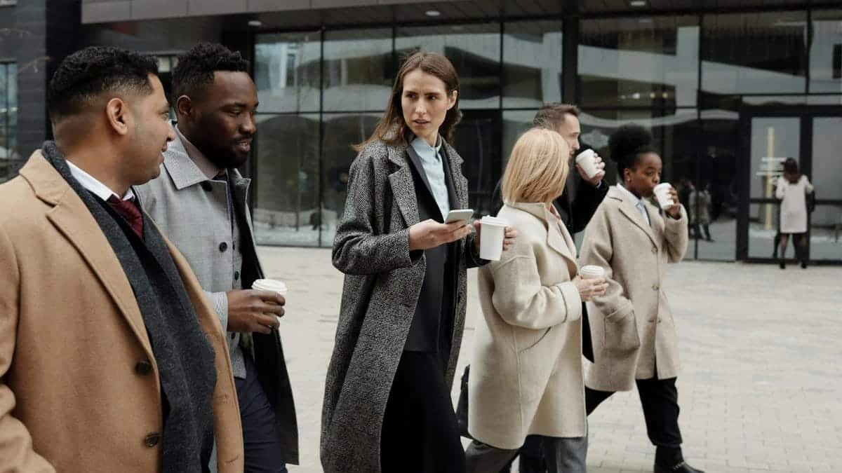 A group of diverse business professionals enjoying a coffee break outdoors in the city.