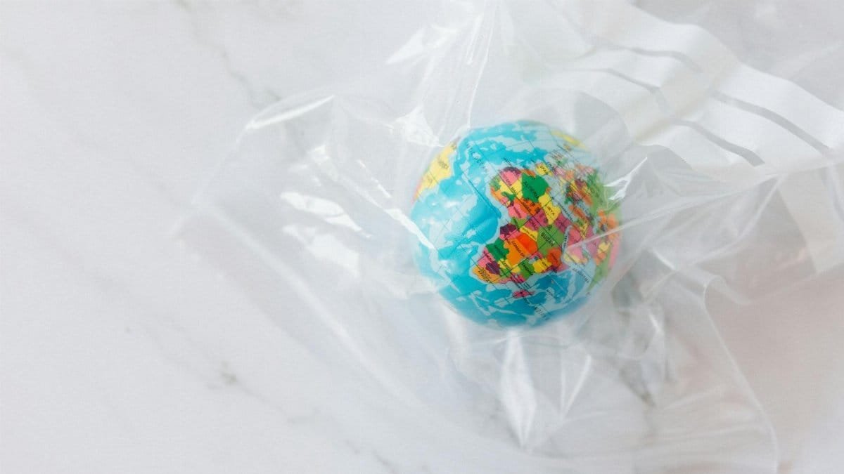 Mini globe encased in a plastic bag symbolizing environmental concerns about plastic waste.