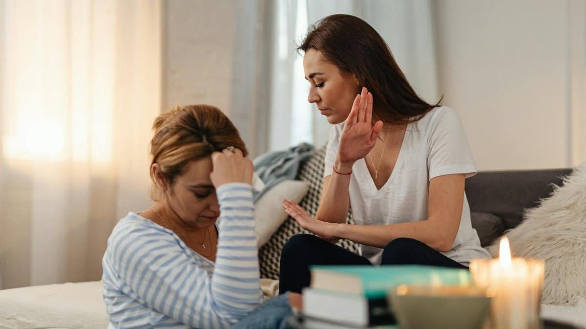 Two women in a tense emotional exchange in a cozy home setting.