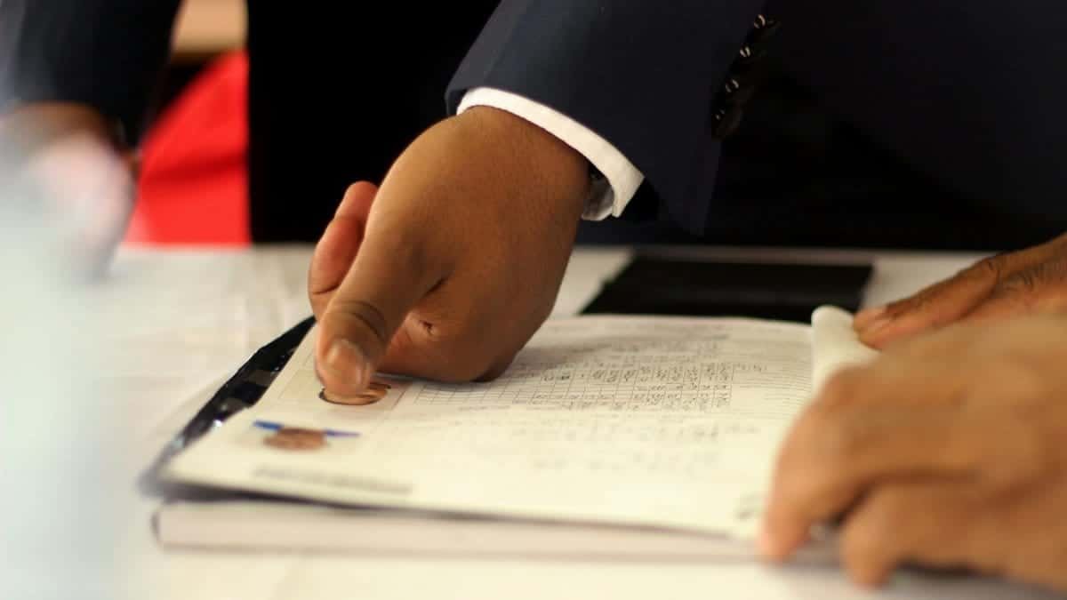 Close-up of a businessman's hand placing a fingerprint on a document for authentication.