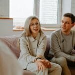 A couple and therapist engaged in a discussion during a therapy session indoors.