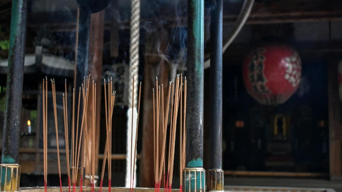 Incense sticks burning in a traditional Tokyo shrine with smoke rising delicately.