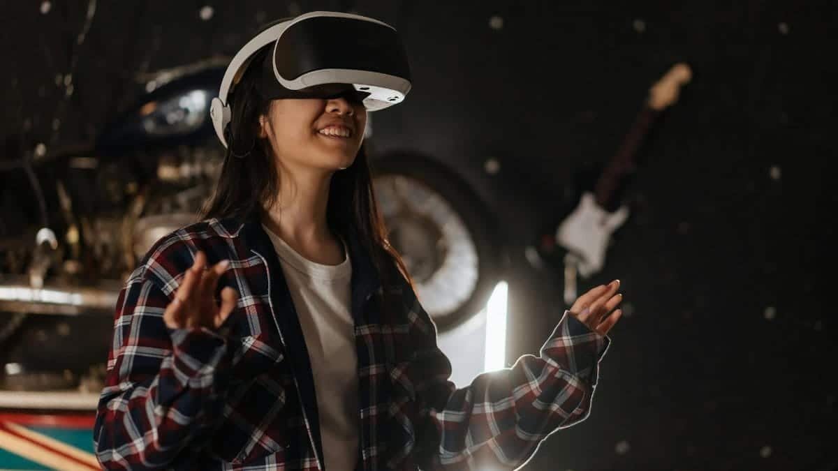 Young woman immersed in virtual reality using a VR headset, enjoying a digital world indoors.